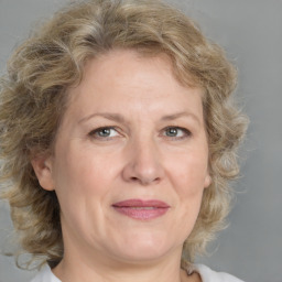 Joyful white adult female with medium  brown hair and grey eyes