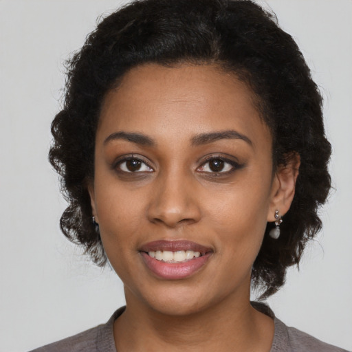 Joyful black young-adult female with short  black hair and brown eyes