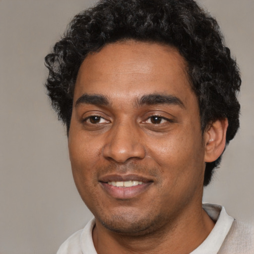 Joyful black young-adult male with short  black hair and brown eyes