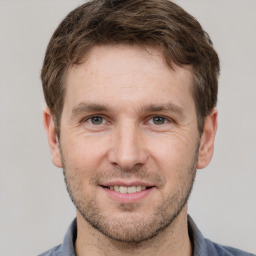 Joyful white adult male with short  brown hair and grey eyes