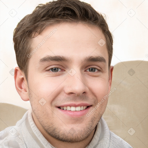 Joyful white young-adult male with short  brown hair and grey eyes