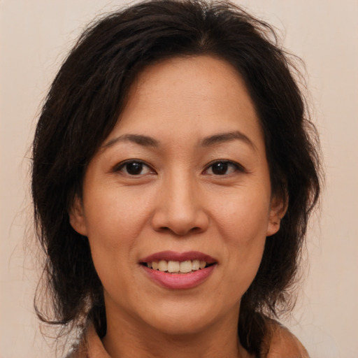 Joyful latino adult female with medium  brown hair and brown eyes