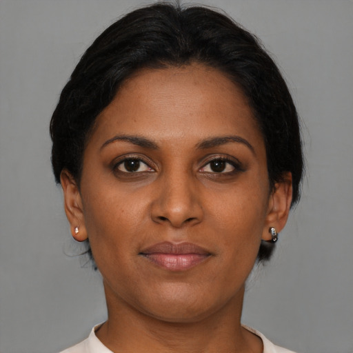 Joyful black young-adult female with short  brown hair and brown eyes