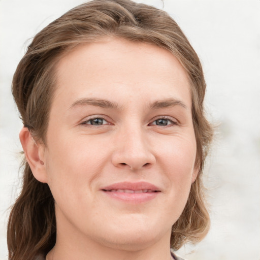 Joyful white young-adult female with long  brown hair and blue eyes