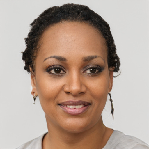 Joyful black young-adult female with short  brown hair and brown eyes
