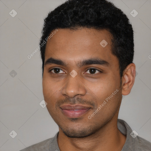 Joyful black young-adult male with short  black hair and brown eyes