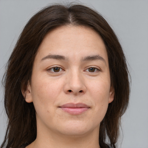 Joyful white young-adult female with long  brown hair and brown eyes