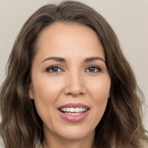 Joyful white young-adult female with long  brown hair and brown eyes