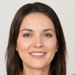 Joyful white young-adult female with long  brown hair and brown eyes