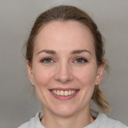 Joyful white adult female with medium  brown hair and grey eyes