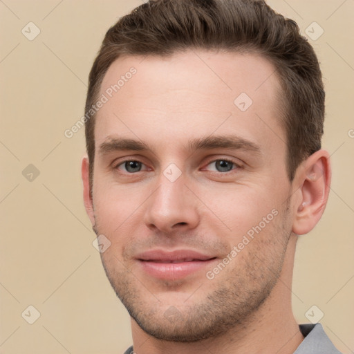 Joyful white young-adult male with short  brown hair and grey eyes