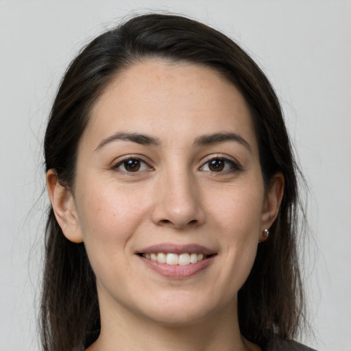 Joyful white young-adult female with long  brown hair and brown eyes