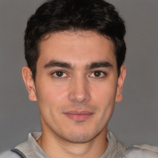 Joyful latino young-adult male with short  brown hair and brown eyes