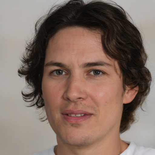 Joyful white adult male with medium  brown hair and brown eyes