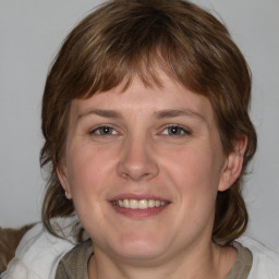 Joyful white young-adult female with medium  brown hair and blue eyes