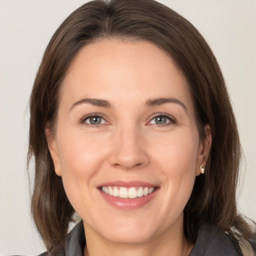 Joyful white young-adult female with medium  brown hair and brown eyes