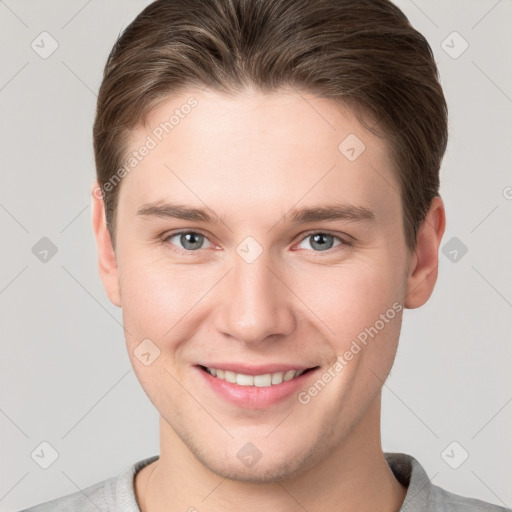 Joyful white young-adult male with short  brown hair and grey eyes