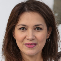Joyful white adult female with long  brown hair and brown eyes