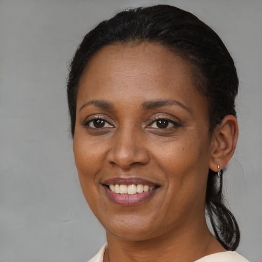 Joyful black young-adult female with medium  brown hair and brown eyes