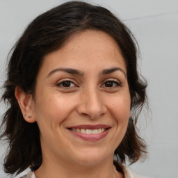 Joyful white adult female with medium  brown hair and brown eyes