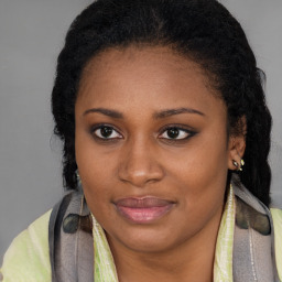 Joyful black young-adult female with long  brown hair and brown eyes