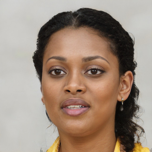 Joyful black young-adult female with long  black hair and brown eyes