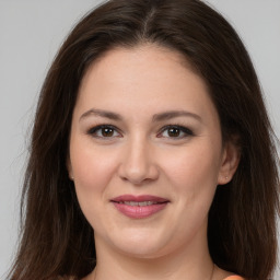 Joyful white young-adult female with long  brown hair and brown eyes