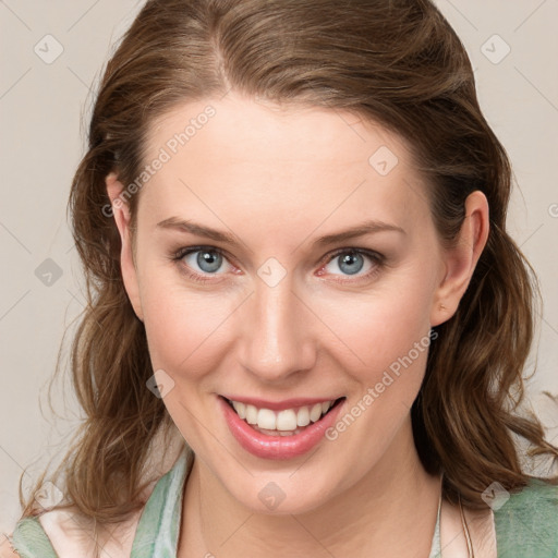 Joyful white young-adult female with medium  brown hair and blue eyes