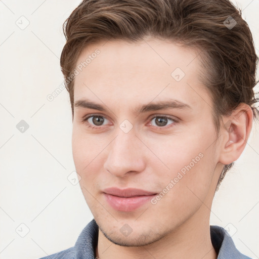 Joyful white young-adult male with short  brown hair and grey eyes