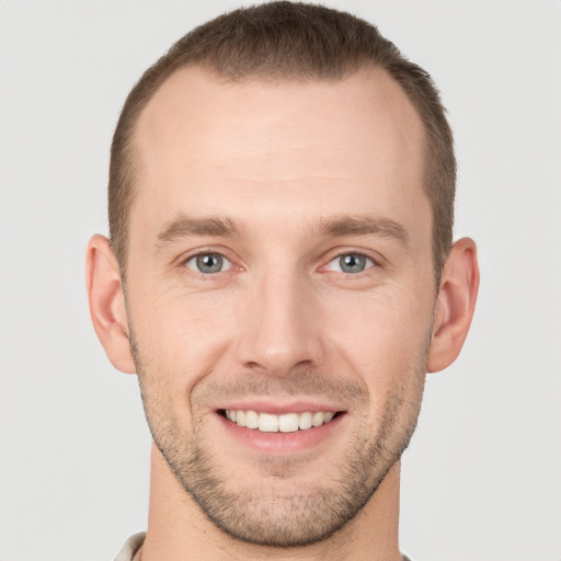 Joyful white young-adult male with short  brown hair and grey eyes