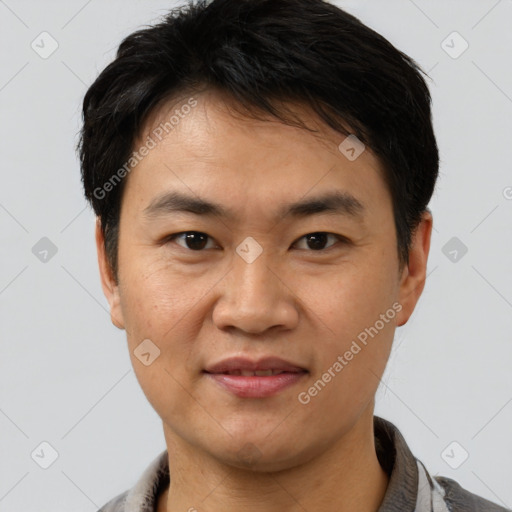 Joyful asian young-adult male with short  black hair and brown eyes