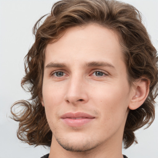 Joyful white young-adult male with medium  brown hair and green eyes