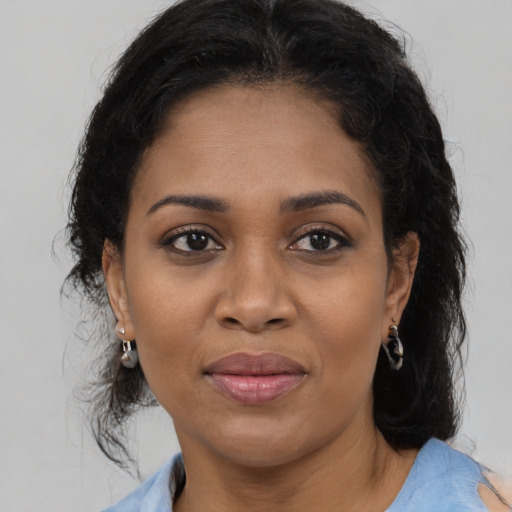 Joyful black adult female with medium  brown hair and brown eyes