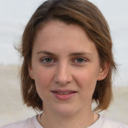 Joyful white young-adult female with medium  brown hair and blue eyes