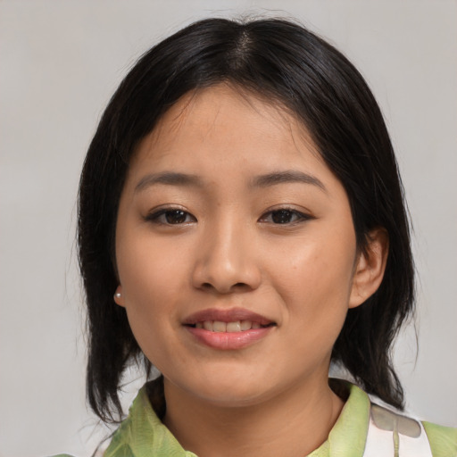 Joyful asian young-adult female with medium  black hair and brown eyes