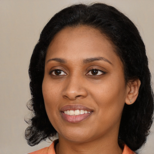 Joyful black young-adult female with medium  black hair and brown eyes