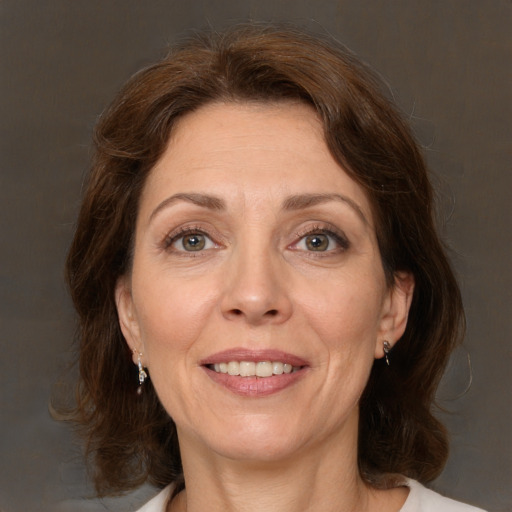 Joyful white adult female with medium  brown hair and green eyes