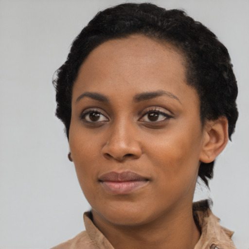 Joyful black young-adult female with short  black hair and brown eyes