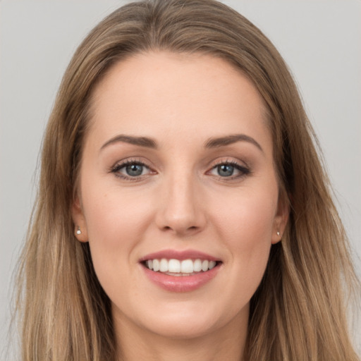 Joyful white young-adult female with long  brown hair and grey eyes