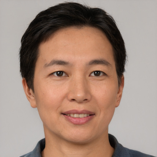 Joyful asian adult male with short  brown hair and brown eyes