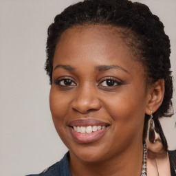 Joyful black young-adult female with long  brown hair and brown eyes