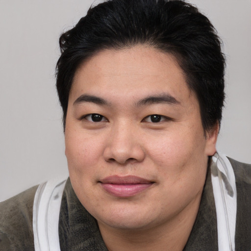 Joyful asian young-adult male with medium  brown hair and brown eyes