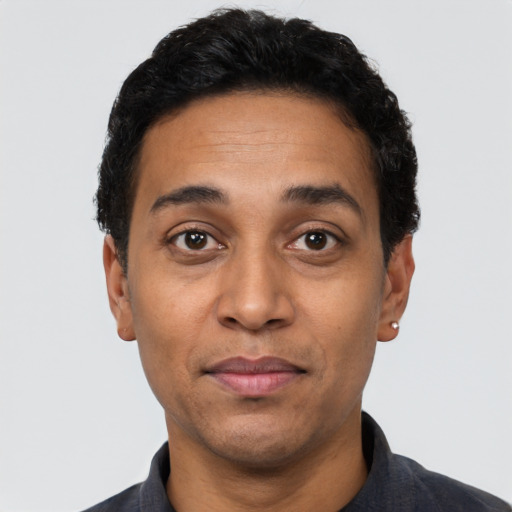 Joyful latino adult male with short  black hair and brown eyes