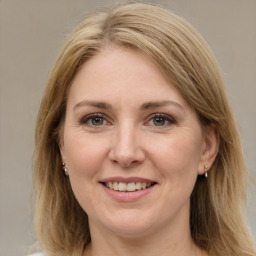 Joyful white adult female with long  brown hair and grey eyes