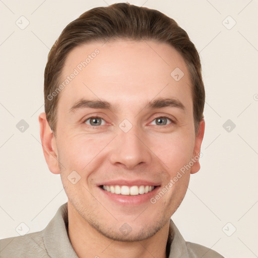 Joyful white young-adult male with short  brown hair and grey eyes