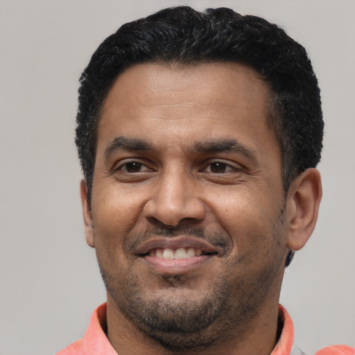 Joyful latino adult male with short  black hair and brown eyes