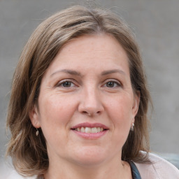 Joyful white adult female with medium  brown hair and grey eyes