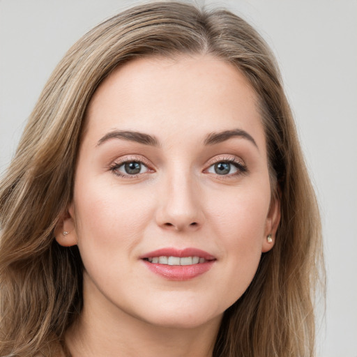 Joyful white young-adult female with long  brown hair and blue eyes