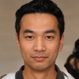 Joyful asian young-adult male with short  black hair and brown eyes