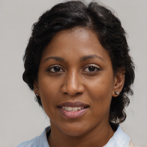 Joyful black adult female with medium  brown hair and brown eyes